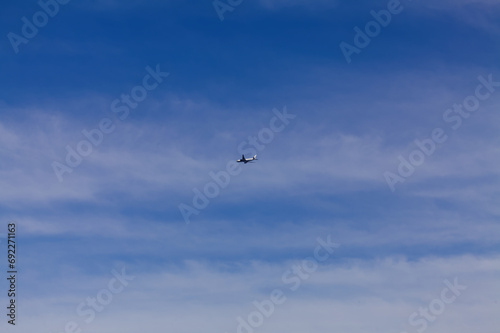 Distant Shot Of Commercial Airliner In Cloudy Blue Sky