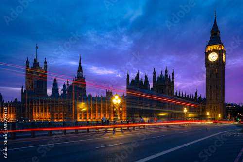 Exterior of historic buildings with glowing lights located against Big Ben tower at night in London city