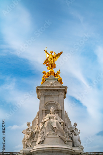 From below of Queen Victoria Memorial monument located at the end of The Mall in front of The Buckingham Palace under cloudy blue sky in Westminster, London