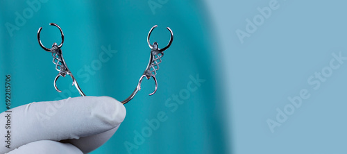 Cobalt chrome removable skeletal prosthesis. The doctor shows a removable metal prosthesis. Toilet isolated on light blue background, with space for text. Dental service concept.