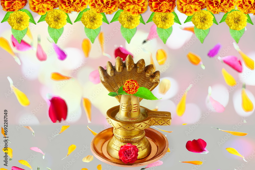 golden metal shivalinga idol for adoration to lord Shiva hindu god with flower garland,flower petal,bael leaves - obrazy, fototapety, plakaty 