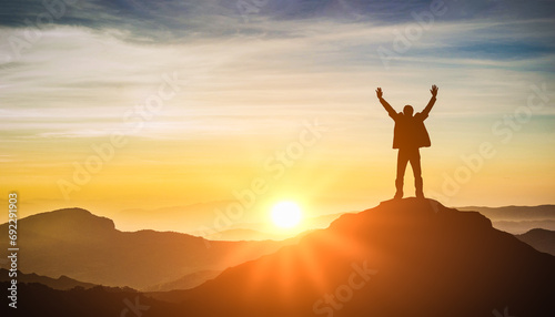 Silhouette of man celebrating raising arms on top of mountain and sunset. concept successful achievement with goal  growth  up  leadership  win and objective target