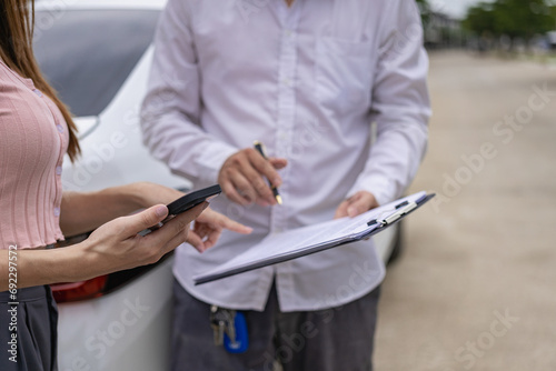 Insurance worker checks damaged car and customer signature in process after traffic accident and insurance concept, close-up photo