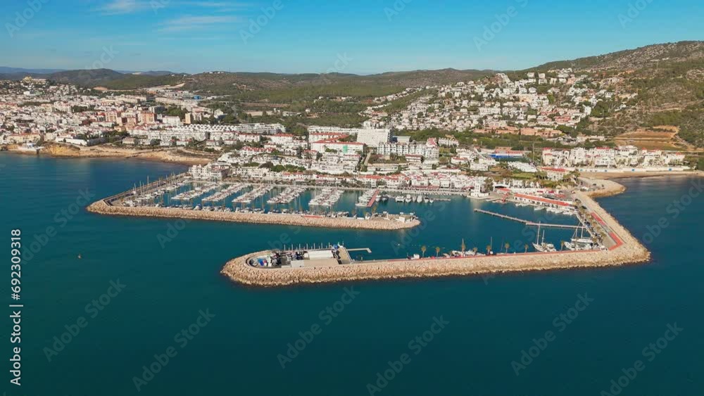 Drone captures docking town in sunny weather with a beautiful blue sea coast backdrop Drone captures docking town in sunny weather with a beautiful blue sea coast backdrop