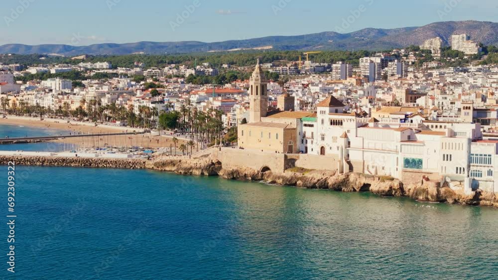Drone captures charming old church surrounded by sailors' town in sunny weather with a beautiful blue sea coast backdrop Drone captures charming old church surrounded by sailors' town in sunny weather with a beautiful blue sea coast backdrop