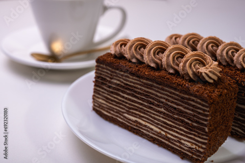 chocolate cream cake with tea, coffee with a piece of spartak, on a light backgroun photo