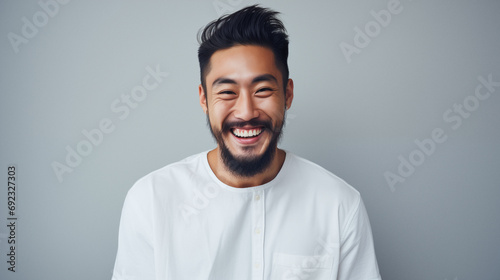 Happy young asian man with beard and stylish hairstyle. Positive expression studio portrait. AI generated. photo