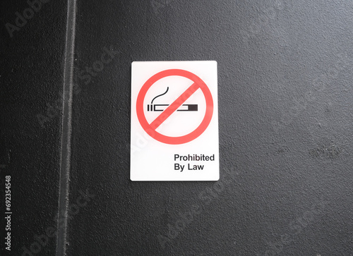 Photography No smoking sign with text Prohibited By Law hanging on the wall at the publish