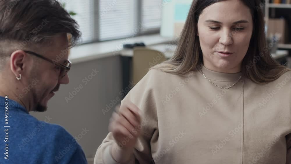 Tilting shot of Caucasian wheelchaired couple of colleagues greeting each other warmly with hug while meeting in office during workday Tilting shot of Caucasian wheelchaired couple of colleagues greeting each other warmly with hug while meeting in office during workday