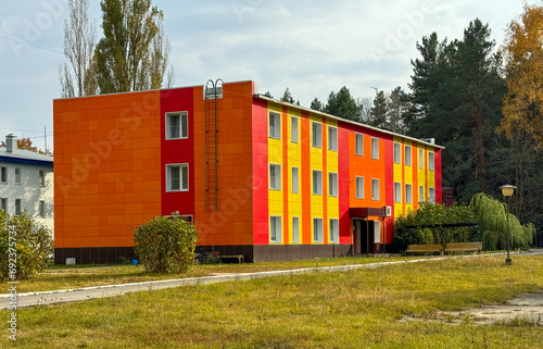 Red three-story building in nature