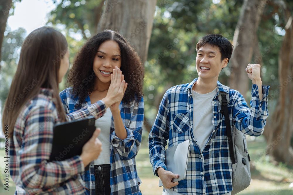 Happy group of college students use laptop feel excited overjoyed triumph with good news over smartphone or Tablet. Happy group of college students use laptop feel excited overjoyed triumph with good news over smartphone or Tablet.
