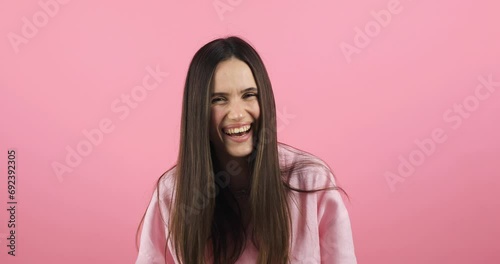 Young excited cheerful funny brunette woman look camera laugh smiling watch comedy movie, listening joke, pointing index finger on you isolated on pink background studio portrait. photo