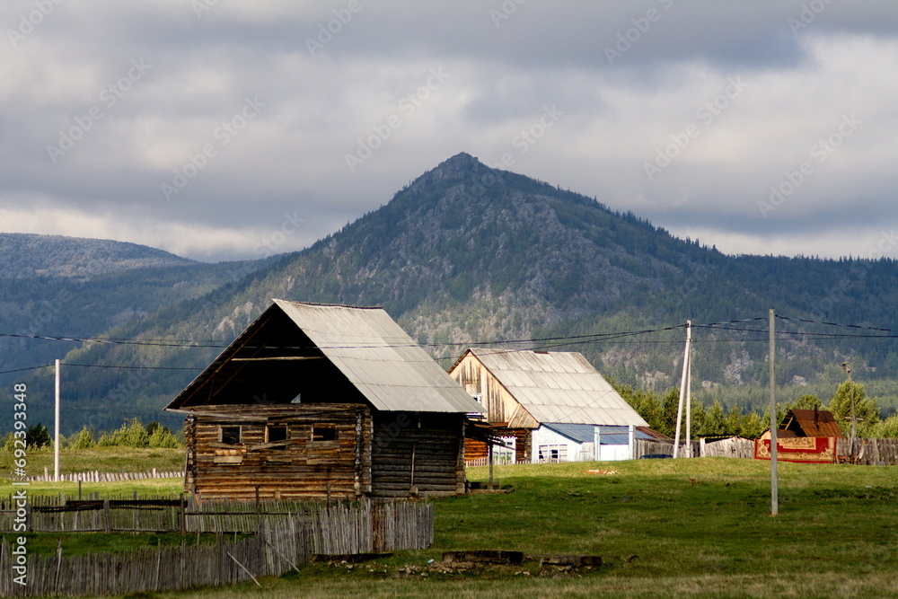 the village of Verkhnearshinsky in the Beloretsk region of Bashkortostan against the backdrop of the Kumardak ridge on a cloudy day