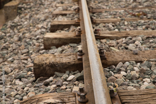 Detail of the rail of the railway track, stones, screw and wooden sleepers. Concept of means of transport.