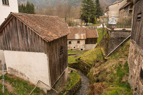 Historic stone buildings by a small stream in the mountain village of Magnanins near Rigolato in Carnia, Friuli-Venezia Giulia, north east Italy