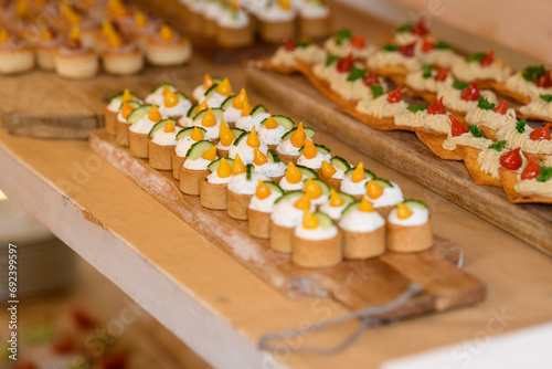 Close-up of assorted canapes on wooden chopping boards at a party photo