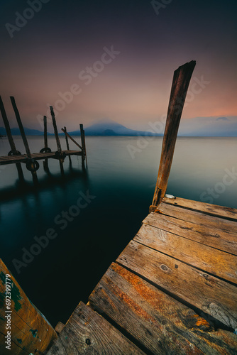 Wooden pier at Lake Atitlan with Distant volcano at sunrise, Solola, Guatemala photo