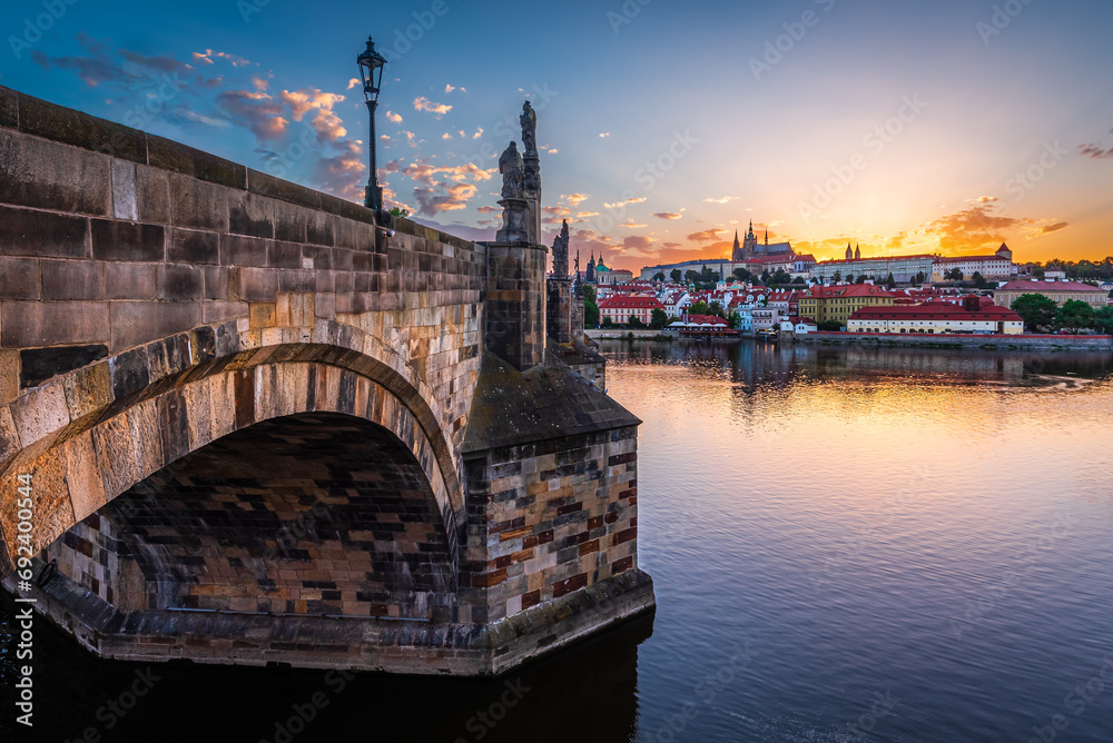 The UNESCO world heritage site Charles Bridge and Prague castle on the summer solstice day when sun sets behind the castle.