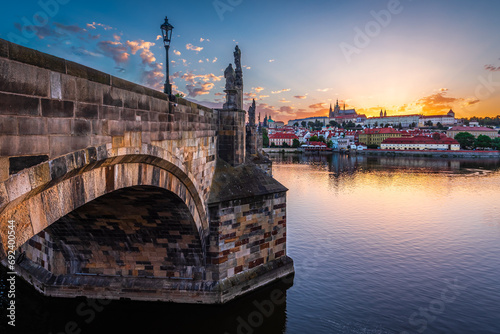 The UNESCO world heritage site Charles Bridge and Prague castle on the summer solstice day when sun sets behind the castle. photo