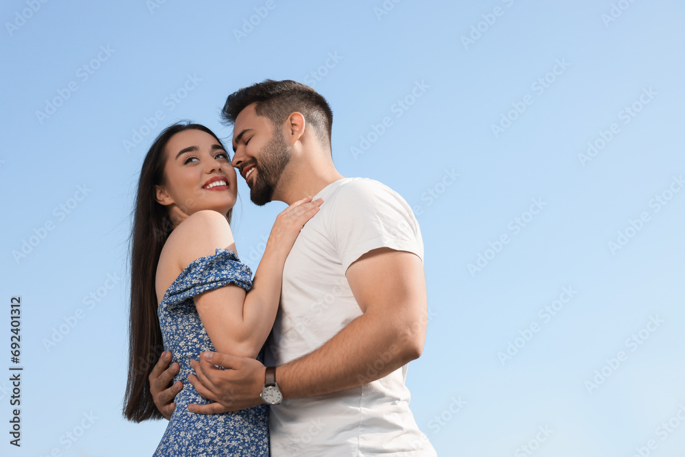 Romantic date. Beautiful couple spending time together against blue sky, low angle view with space for text Romantic date. Beautiful couple spending time together against blue sky, low angle view with space for text