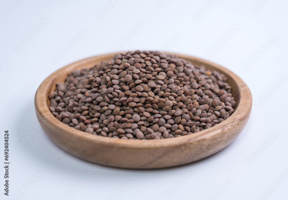Lentils, beans, wooden plate, close-up, white background Lentils, beans, wooden plate, close-up, white background