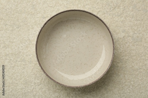 Beautiful ceramic bowl on beige table, top view