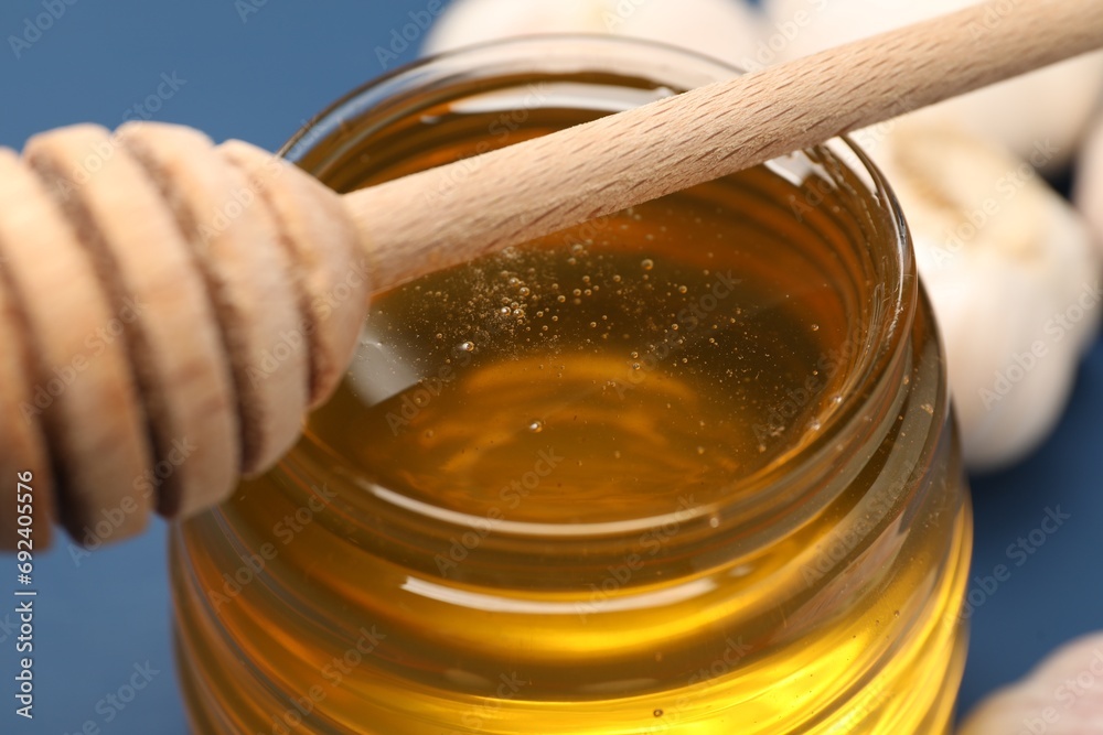 Jar with honey and dipper on table, closeup Jar with honey and dipper on table, closeup