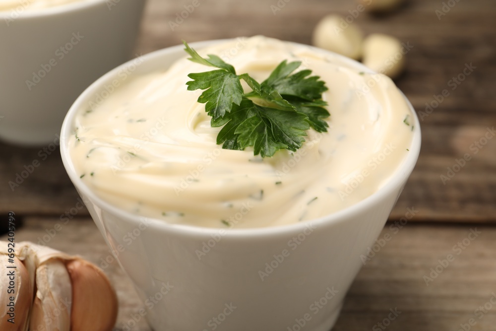 Tasty sauce with garlic and parsley on wooden table, closeup Tasty sauce with garlic and parsley on wooden table, closeup