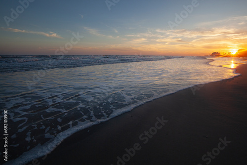 A scenic view of a sunset over a beach on the Gulf of Mexico in Galveston, Texas.