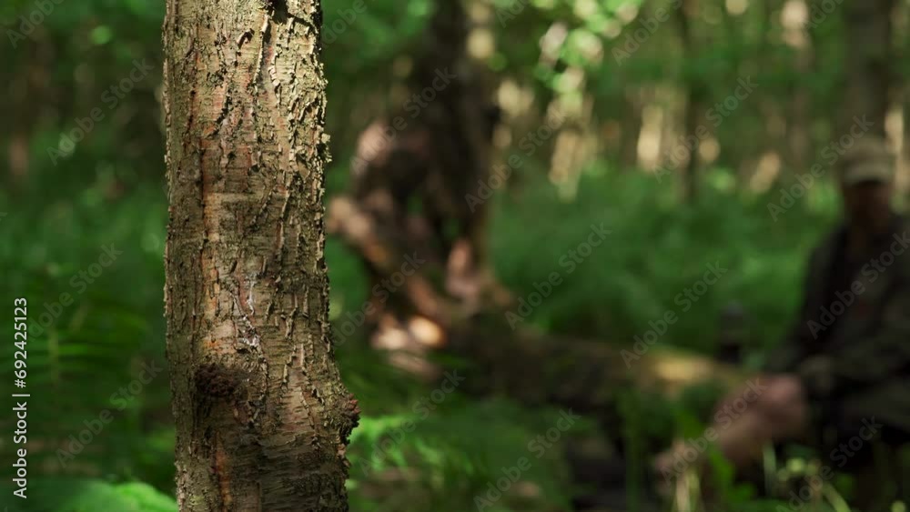 Obscure woodland shot with a man sitting down and looking around Obscure woodland shot with a man sitting down and looking around