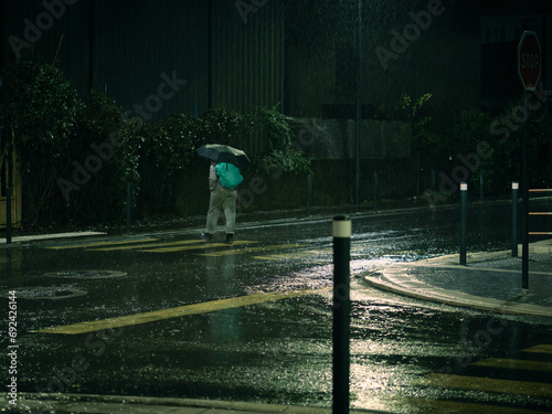 Personne qui marche sous la pluie avec son parapluie