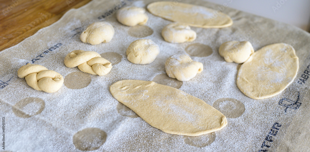 Homemade pastries dusted with flour on a linen cloth in a normal household kitchen