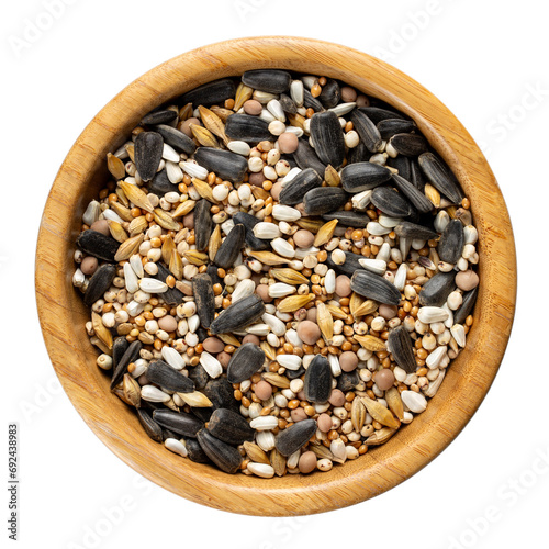 Grain mixture for wild birds. Birdseed for outdoor feeders in wooden bowl isolated on white. Top view. photo