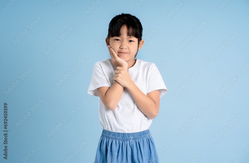 Portrait of Asian girl posing on blue background Portrait of Asian girl posing on blue background