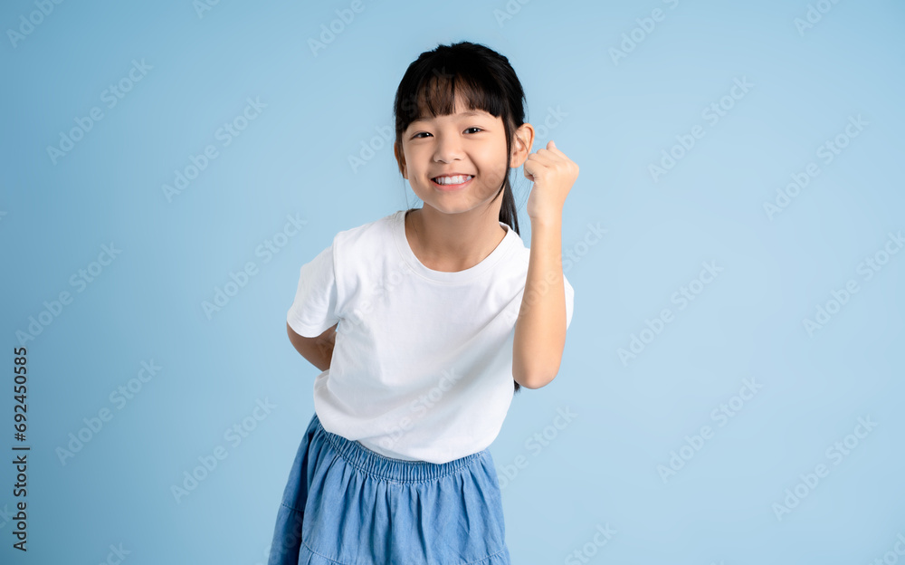 Portrait of Asian girl posing on blue background Portrait of Asian girl posing on blue background