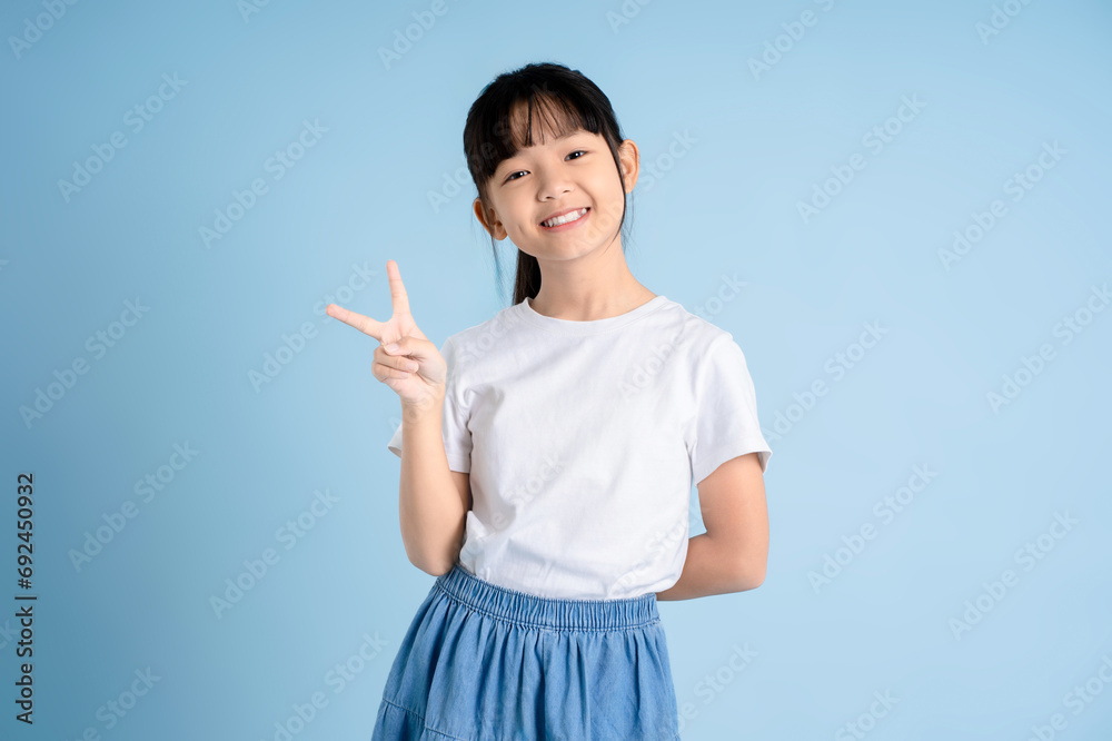 Portrait of Asian girl posing on blue background Portrait of Asian girl posing on blue background