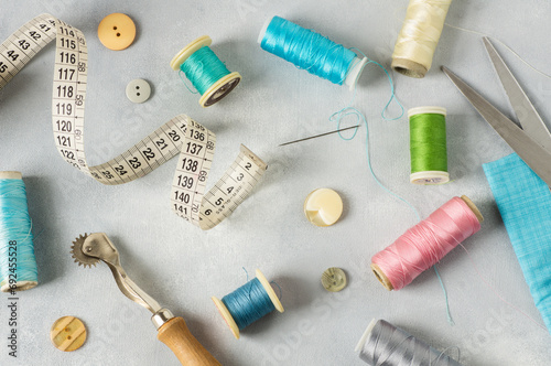 Tailor sewing accessories, craft concept background, scissors, tracing wheel, measure, threads © mescioglu