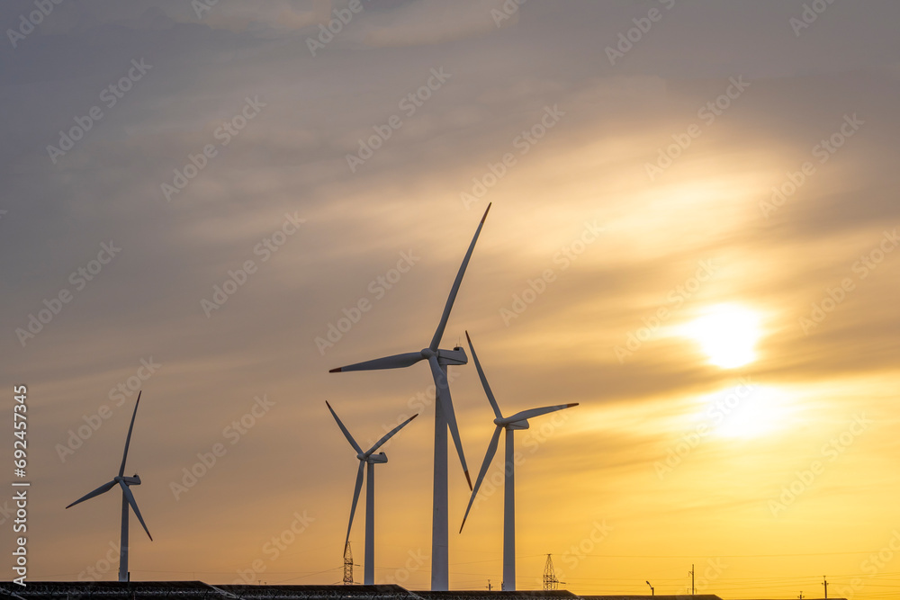 Technological landscape, wind turbines and solar panels at sunset. The power plant is at sunset. Wind turbines and solar panels on a sunset background.