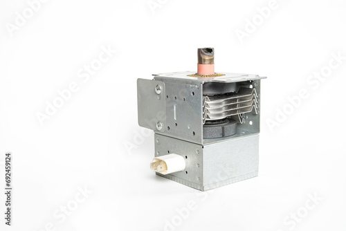 Magnetron on a white background. Magnetron with a burnt metal cap. Magnetron from a microwave oven, the cause of sparks and smoke from a microwave oven. photo