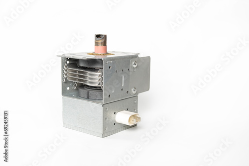 Magnetron on a white background. Magnetron with a burnt metal cap. Magnetron from a microwave oven, the cause of sparks and smoke from a microwave oven. photo