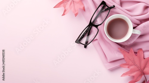 a cup of coffee and glasses on a pink blanket