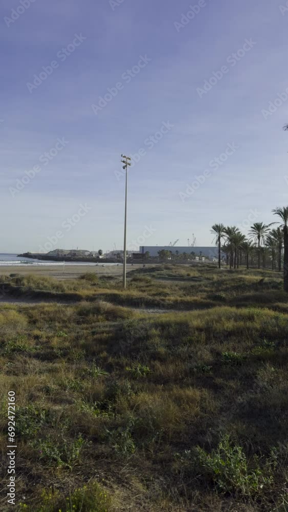 Walk through a sunny city. Bright colourful beach houses on the sandy beach of Spain. Warm sunny day at the end of December. Province of Castellon. Spain sea in winter. Walk through a sunny city. Bright colourful beach houses on the sandy beach of Spain. Warm sunny day at the end of December. Province of Castellon. Spain sea in winter.