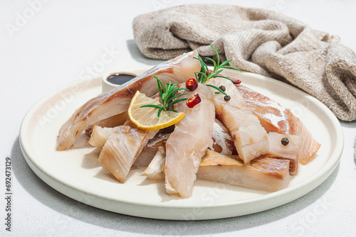 Raw pollock (Pollachius virens) fillet. Fresh fish for healthy food lifestyle. Spices and herbs photo
