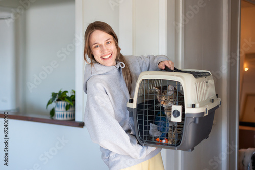 A young female student holding cat in carrier.