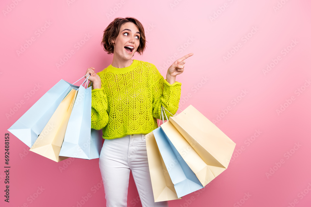 Fototapeta premium Photo of beautiful young girl point finger billboard direct finger look novelty introduce glamour garment isolated on pink color background