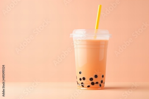 bubble tea in peach fuzz color in a plastic cup with a straw on a pastel peach background, minimalist