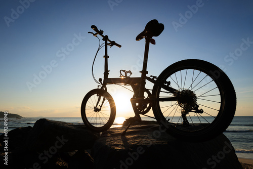A folding bike on sunrise seaside rocks