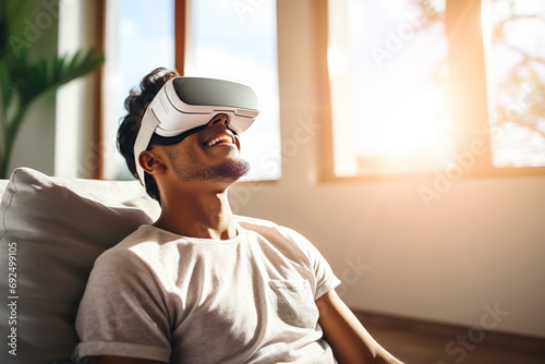 Cheerful man with VR goggles enjoying at home. Technology of the digital cyberworld metaverse. Entering an unreal and futuristic world  © Jsanz_photo