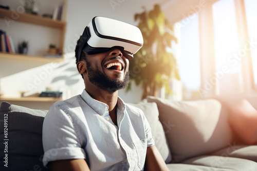 Cheerful man wearing virtual reality goggles at home. Technology of the digital cyberworld metaverse. Entering an unreal and futuristic world  © Jsanz_photo