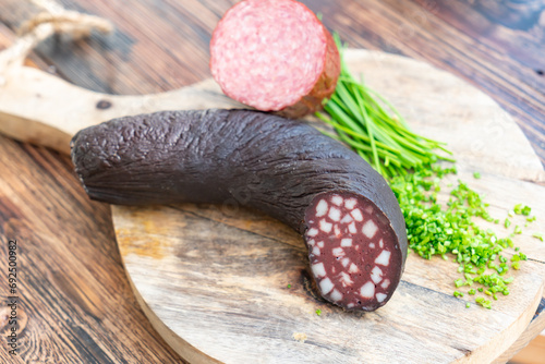 schwarzwurst aufgeschnitten auf holzbrett schön präsentiert  photo